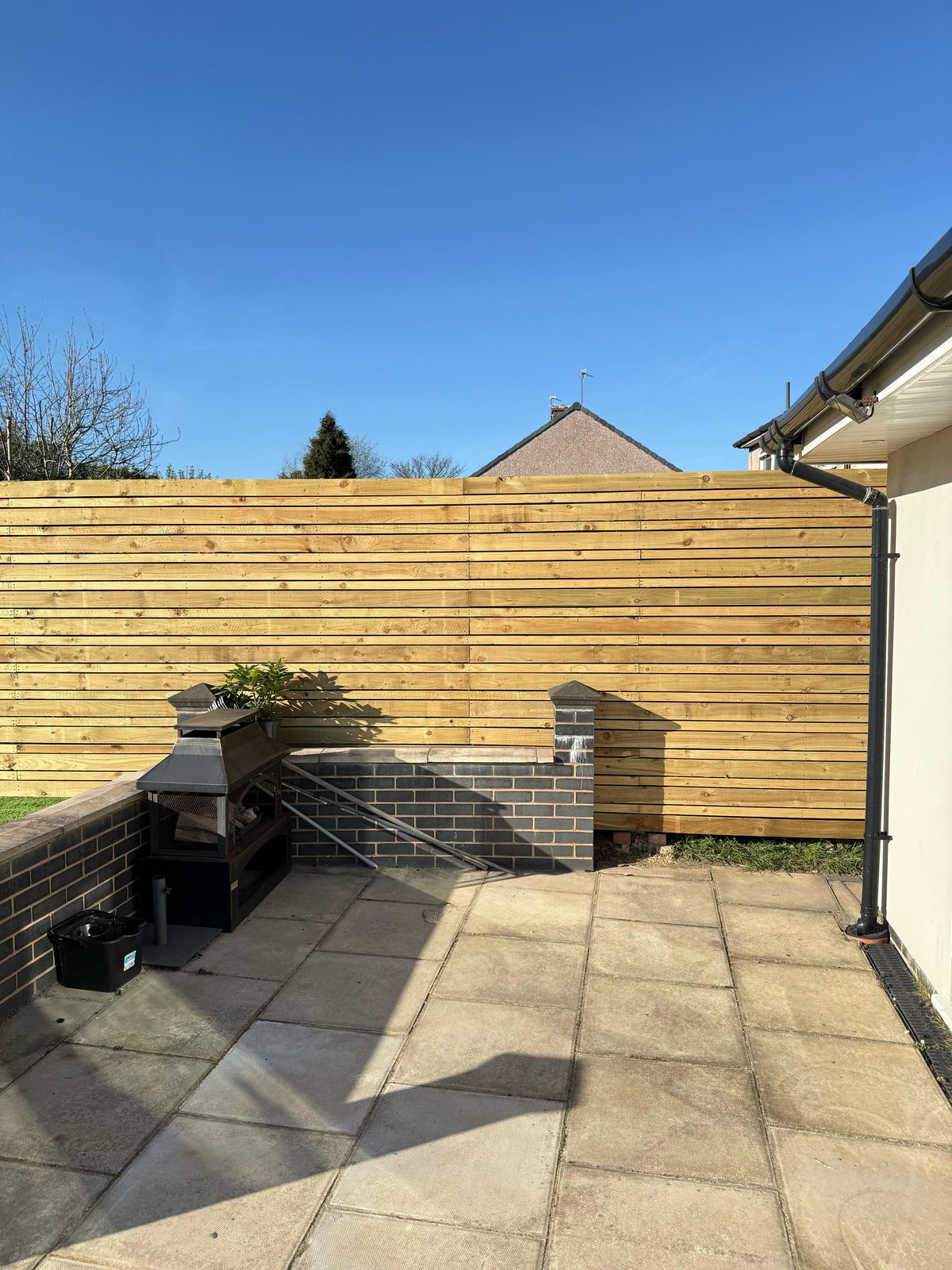 Slatted timber fence above brick wall